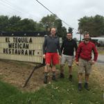 hikers standing by mexican restaurant sign